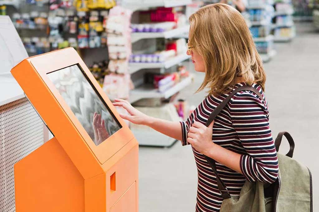 A woman using a digital kiosk